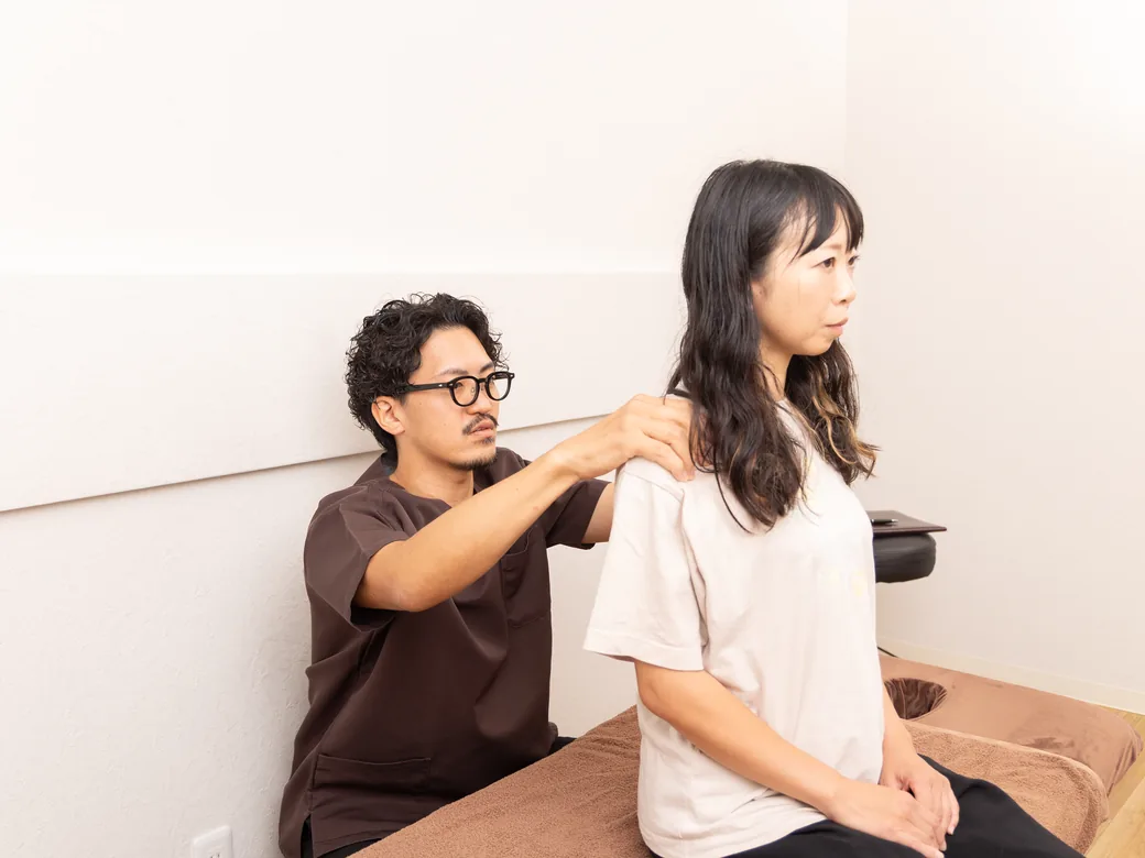 座った姿勢で肩の状態を確認する様子
