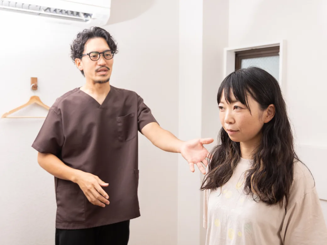 立った姿勢で身体の使い方を説明する院長