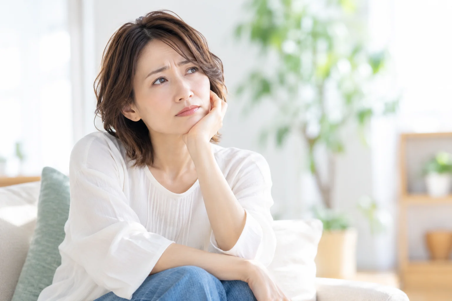 頬杖をついて悩む女性