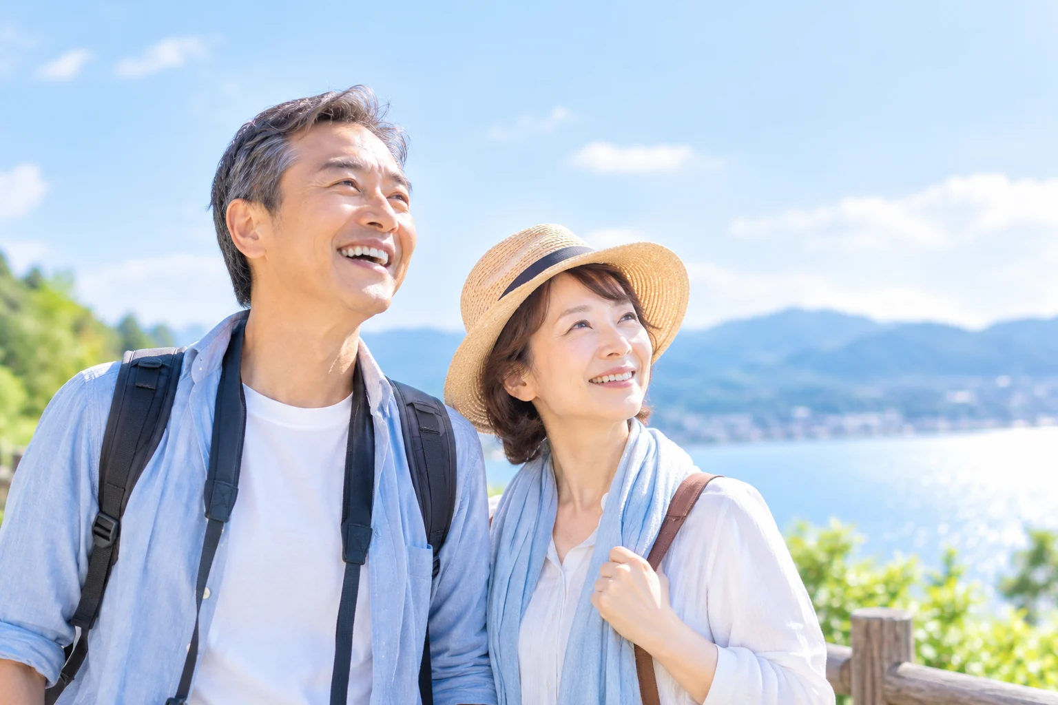 海辺をハイキングするシニア夫婦